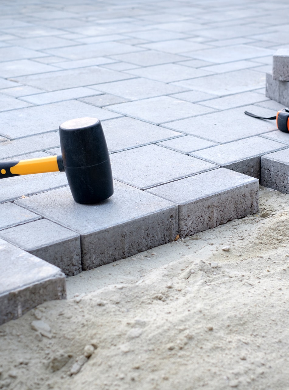 The Master In Yellow Gloves Lays Paving Stones